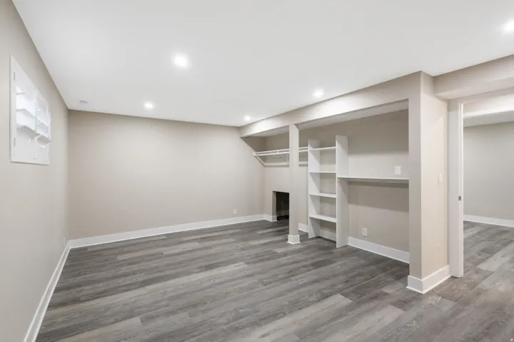 Spacious room featuring recessed lighting, wood-finish flooring, built-in shelving, and a built-in clothing rod