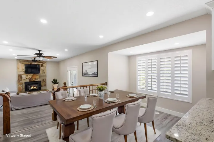Recessed lighting, wood-finish flooring, and a stone fireplace with a built-in hearth
