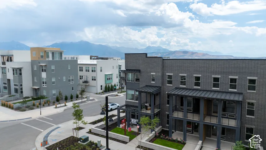 Modern architectural design featuring multi-story residences, dark brick facades, and covered balconies