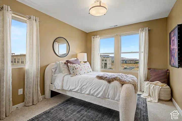 Recessed lighting, wall-to-wall carpeting, and multiple windows with roller shades