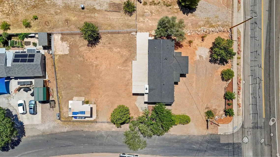 Residential property with a dark shingle roof, accompanied by a detached structure featuring solar panels