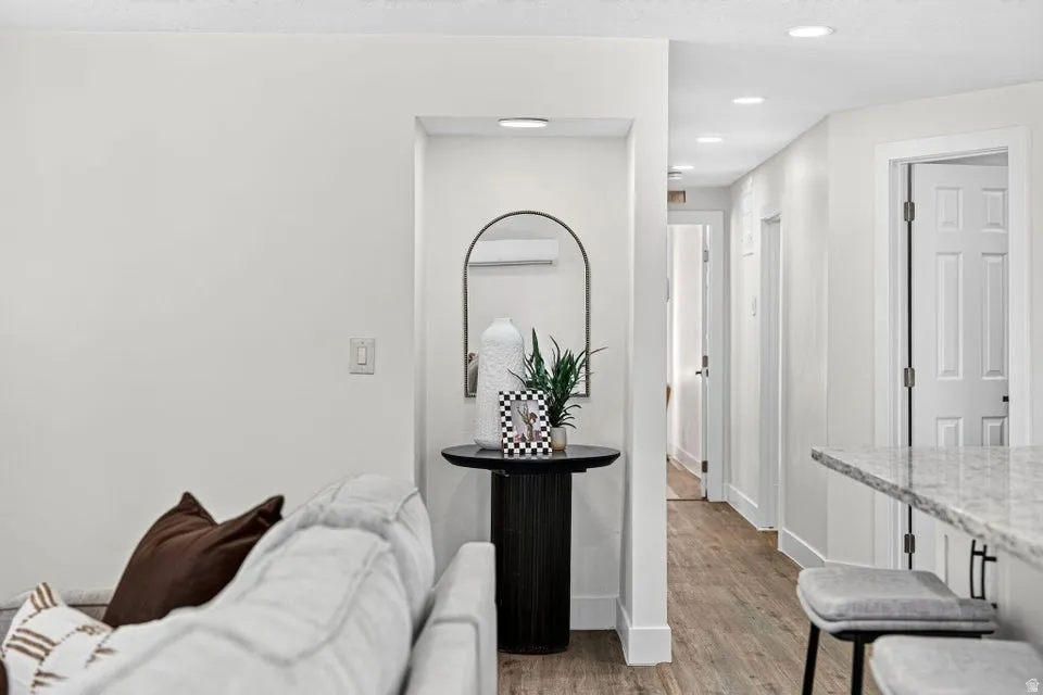 Recessed lighting throughout, wood-finish flooring, white panel doors, and a granite-finish countertop