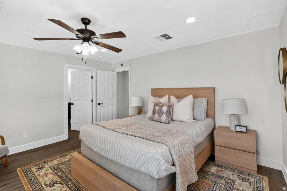 Wood-finish flooring, white paneled doors, ceiling fan with light fixture, recessed ceiling lighting, and white baseboards