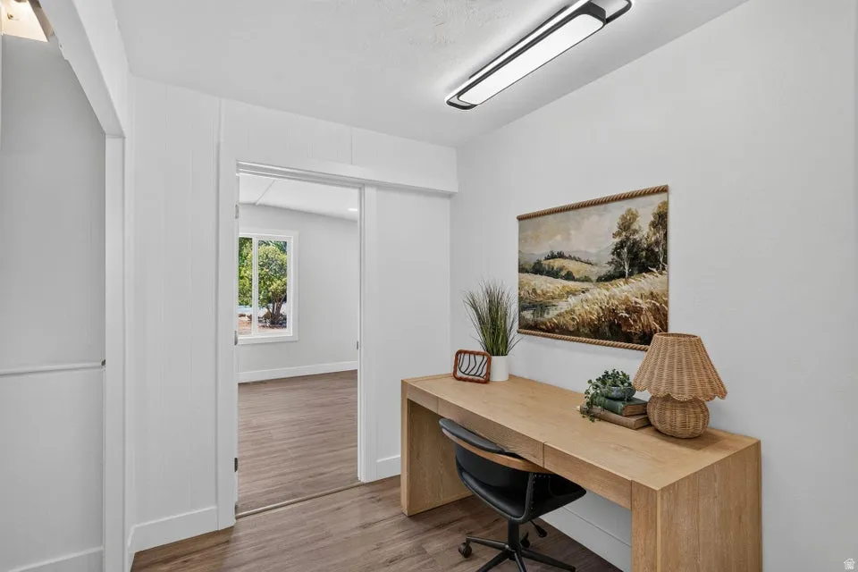 Recessed lighting, wood-finish flooring, white walls, and a sliding door