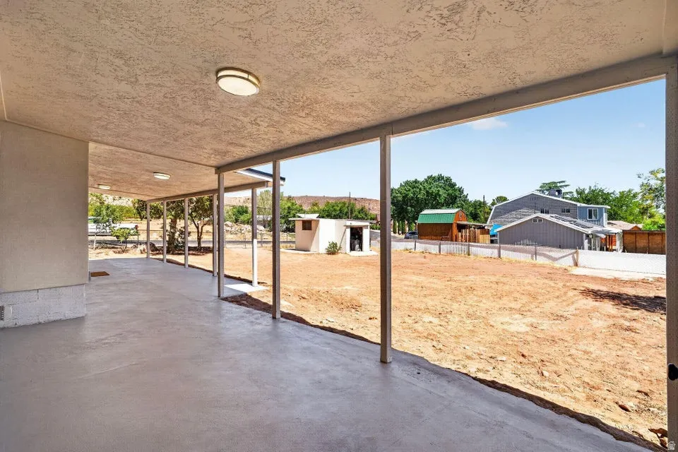 Covered concrete patio with recessed lighting and open-air metal supports