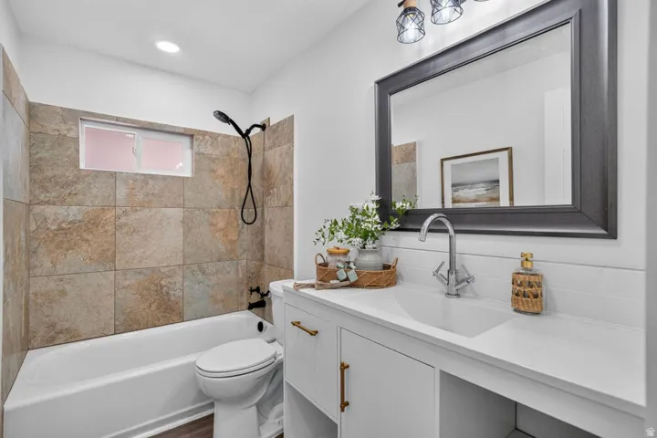 White vanity with gold-tone hardware, rectangular undermount sink, and chrome faucet