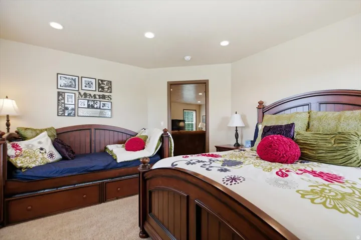 Recessed ceiling lighting, wood-finish beds, and carpet flooring