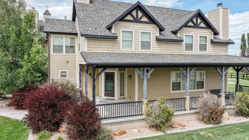 Front exterior with a covered porch, horizontal siding, black trim accents, a multi-pane front door, and a shingled roof