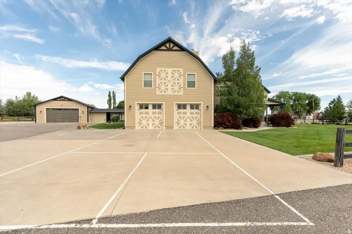 Two-story barn-style structure with two garage doors, horizontal siding, and decorative gables