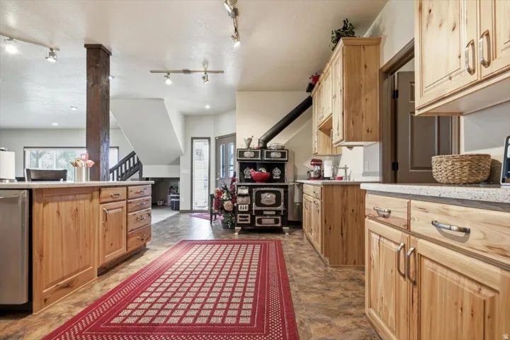 Kitchen featuring wood-finish cabinetry, light-toned countertops, and track lighting