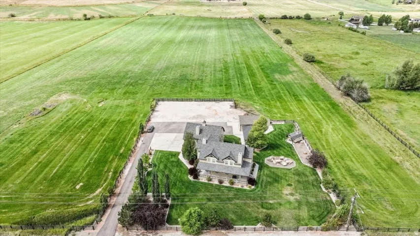 Expansive property featuring a large residence, detached garage, and substantial surrounding acreage