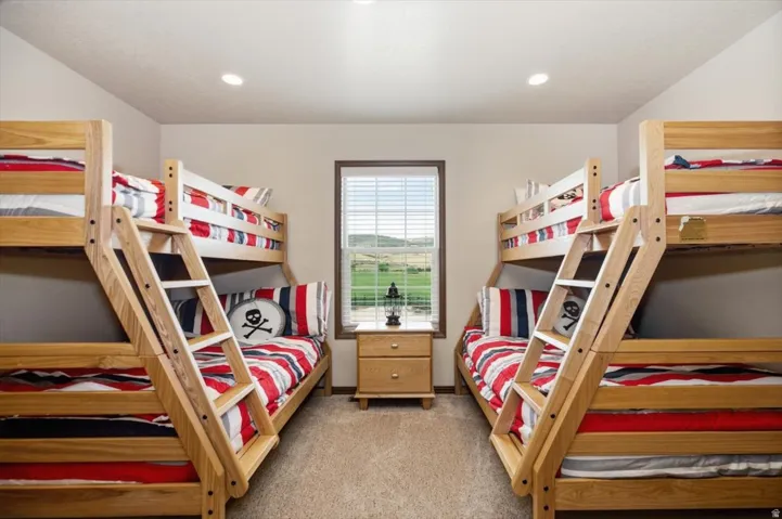 Recessed lighting, wood-frame bunk beds, and a window with horizontal blinds