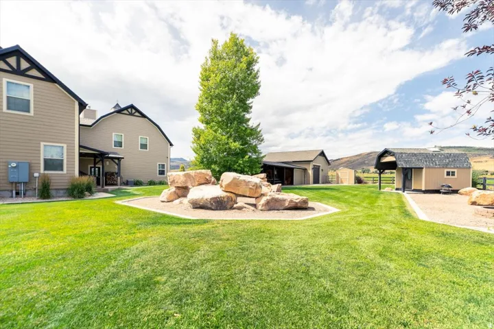 Expansive green lawn with a decorative rock feature