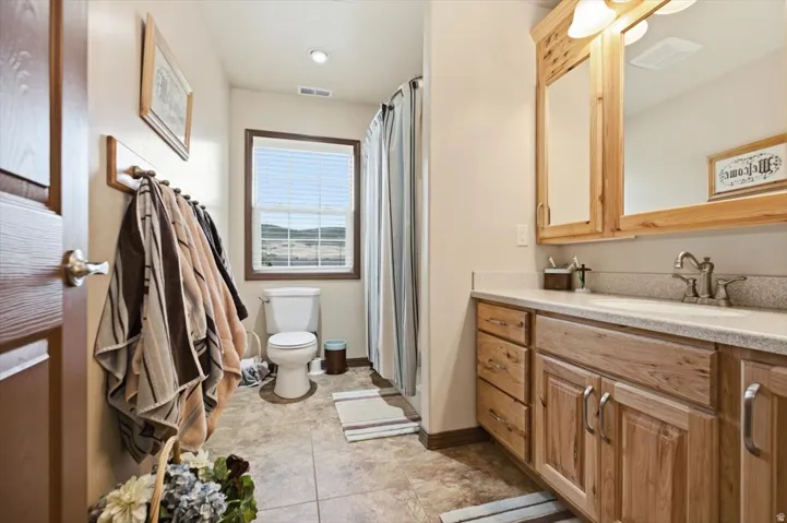 Bathroom with a light-toned vanity featuring a built-in sink and coordinating mirror