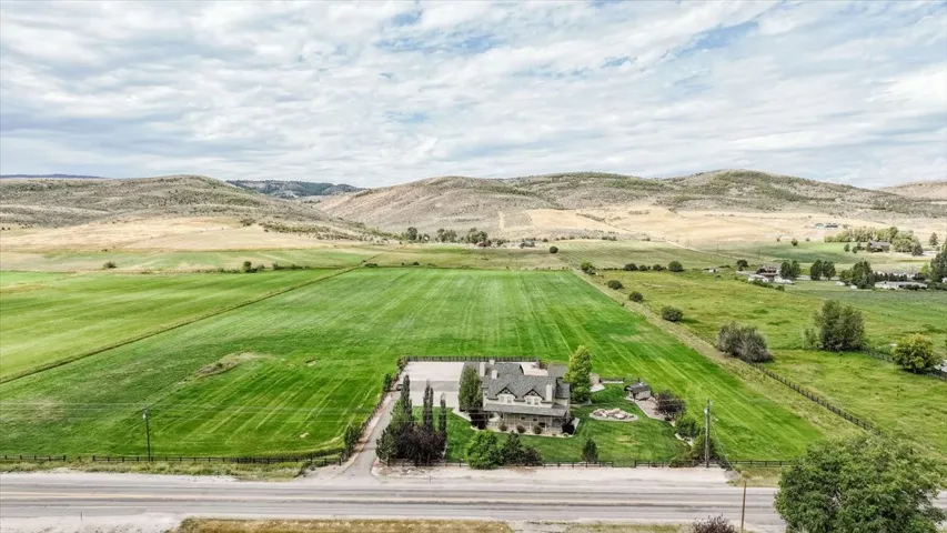 Expansive acreage featuring a substantial main residence with multiple gables and a stone facade