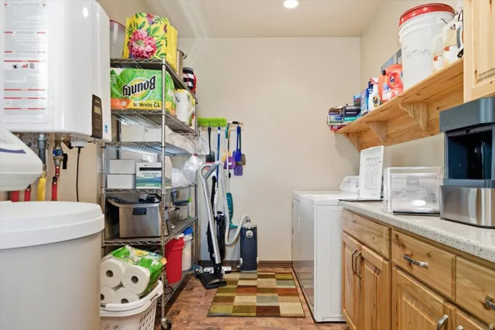 Built-in cabinetry with light-toned wood-finish, light-toned countertop, and undermount washer/dryer hookups