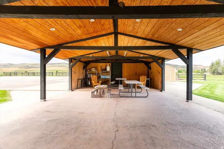 Covered open-air structure with wood-finish ceiling, exposed beams, and recessed lighting
