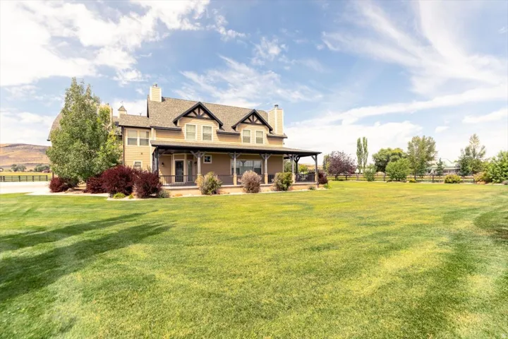 Expansive green lawn and a covered porch with decorative columns