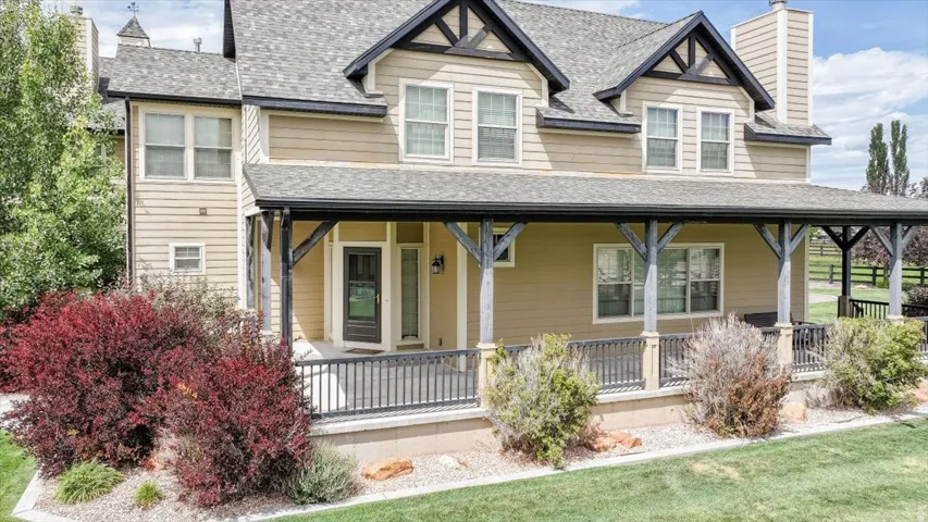 Expansive covered front porch with dark wood columns and railing