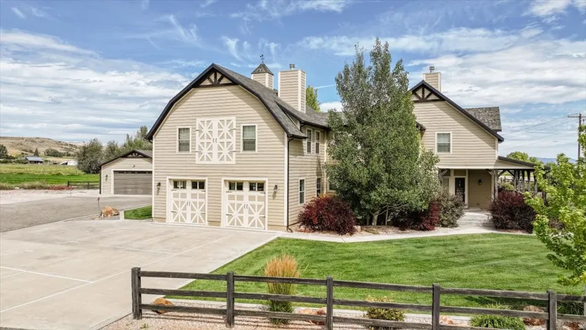 Expansive paved driveway leading to a two-car garage and additional garage structure