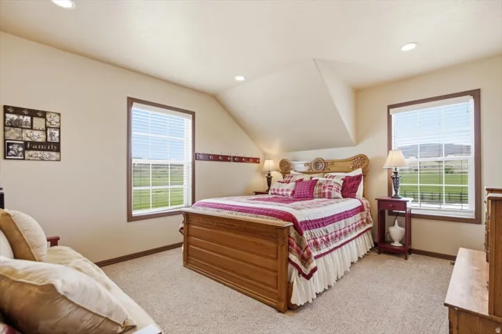 Recessed ceiling lighting, sloped ceiling feature, dual windows, plush carpeting, and wood-trim windows