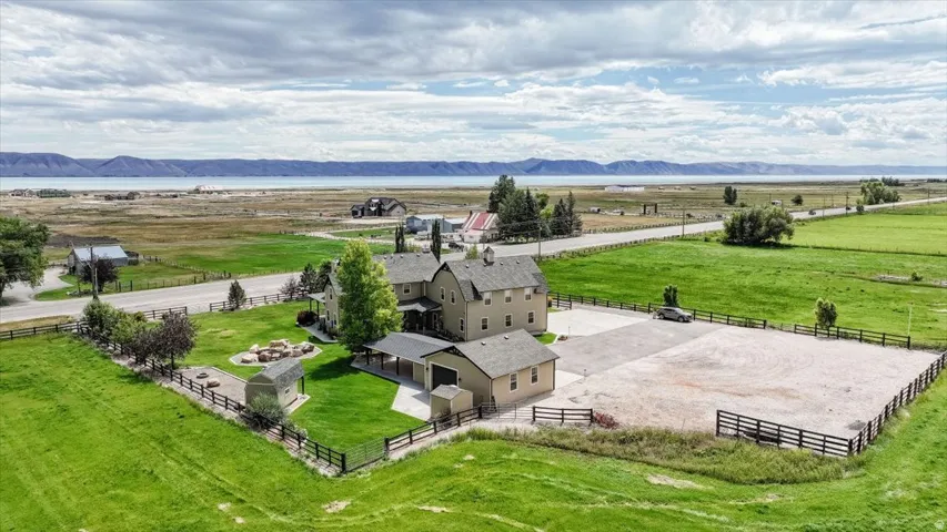 Expansive property featuring a multi-story residence, separate detached garage, and a fenced, level outdoor area