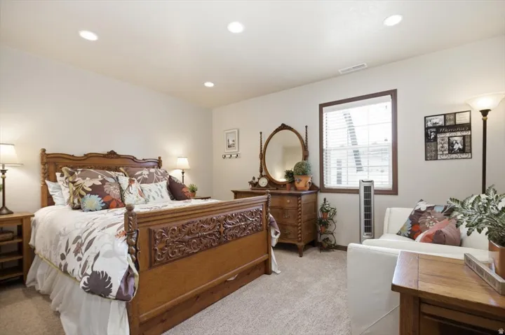Recessed ceiling lighting, window with blinds, light-colored carpeting, white wall paint, and wood-finish trim