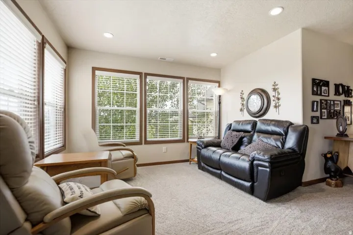 Carpeted flooring, recessed lighting, and multiple windows with wood trim