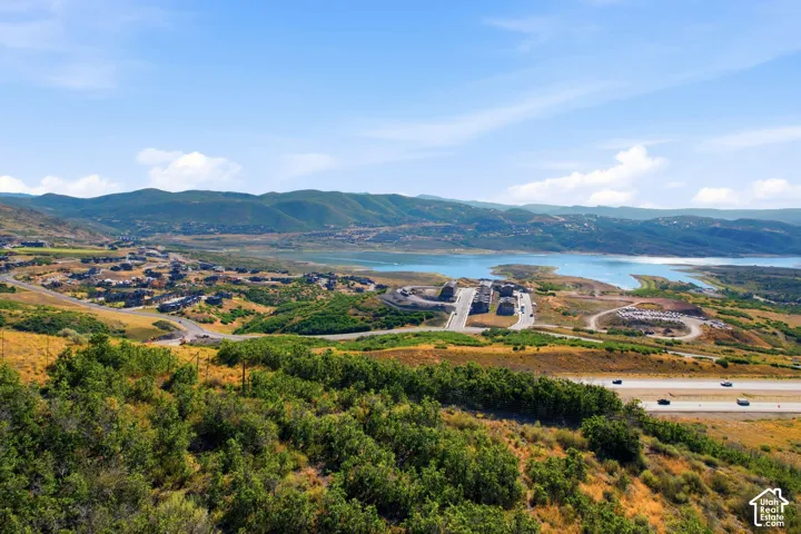 Expansive landscape with mountainous terrain, a large body of water, and residential developments