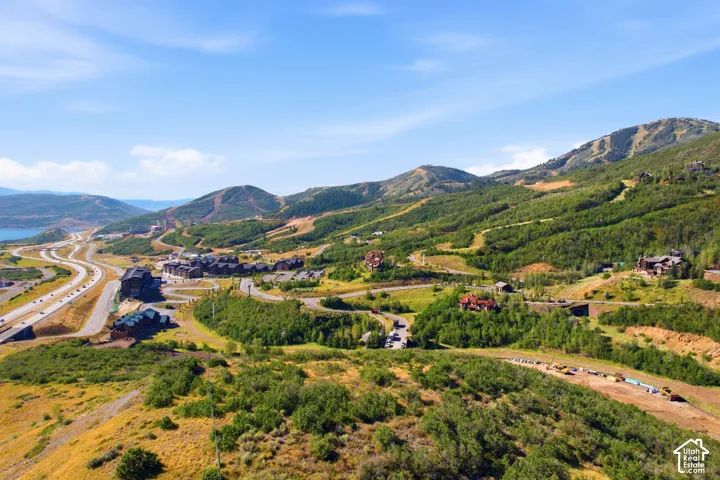 Mountainous terrain with lush green foliage, prominent roadways, and multiple structures
