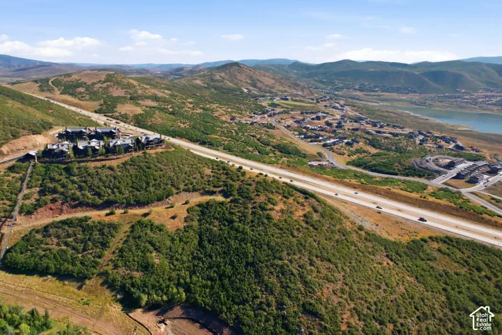 Expansive hillside property featuring a multi-building complex, surrounded by natural vegetation and offering distant water features