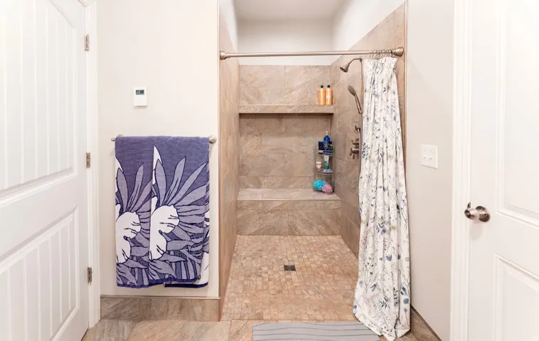 Walk-in shower with full-height tile surround, integrated bench, and recessed shelf
