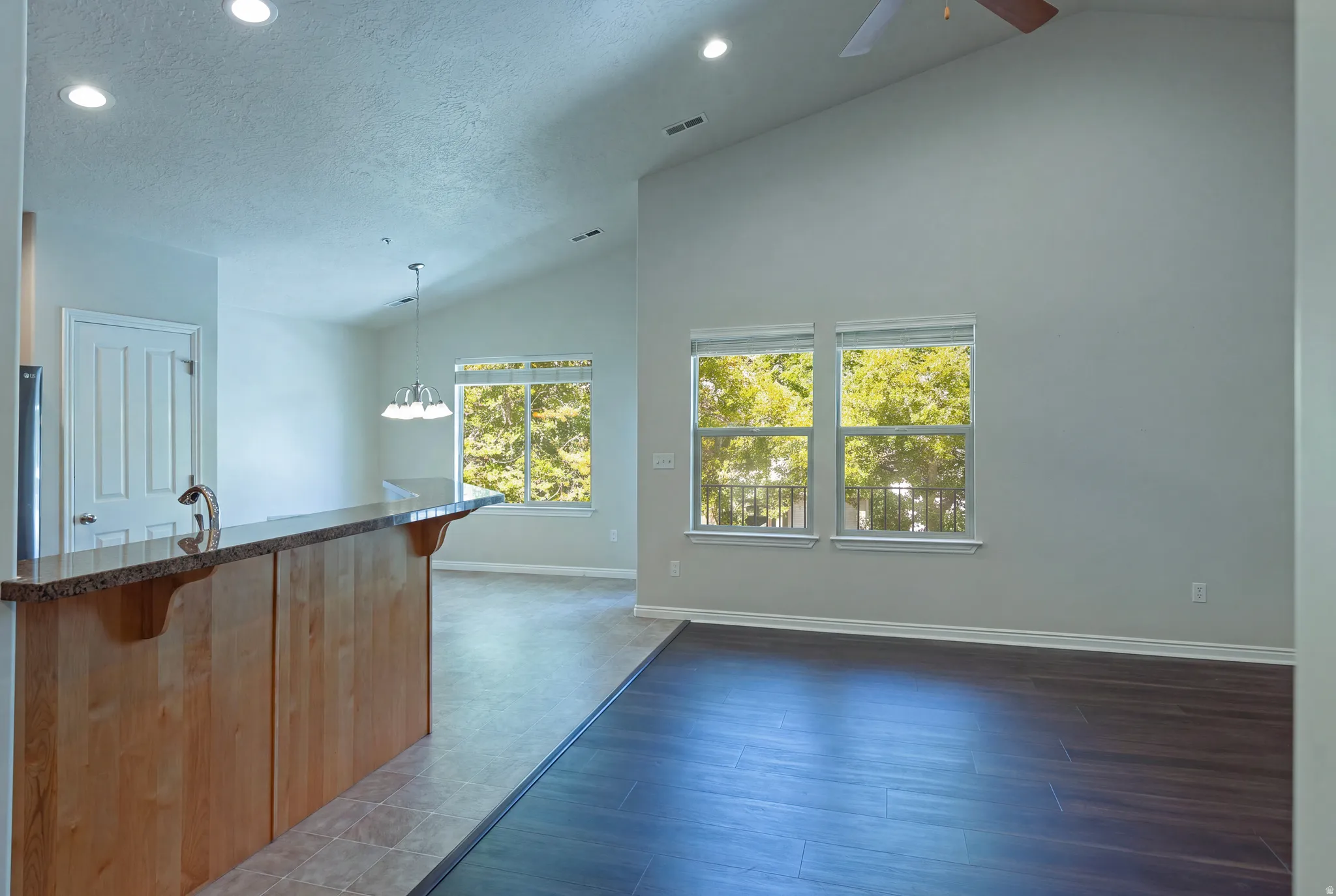 Vaulted ceiling with a ceiling fan, recessed lighting, and multiple windows