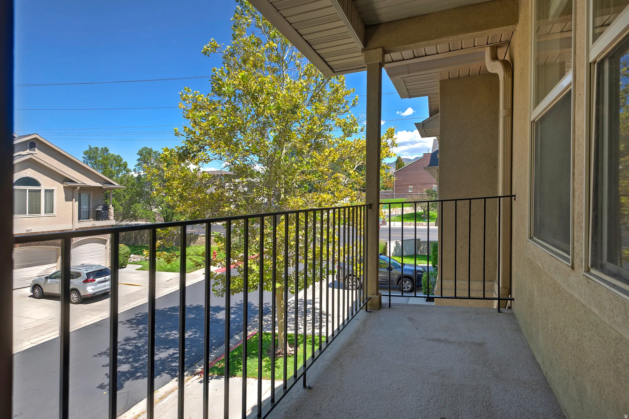 Balcony with a black metal railing and concrete flooring, offering an open-air extension