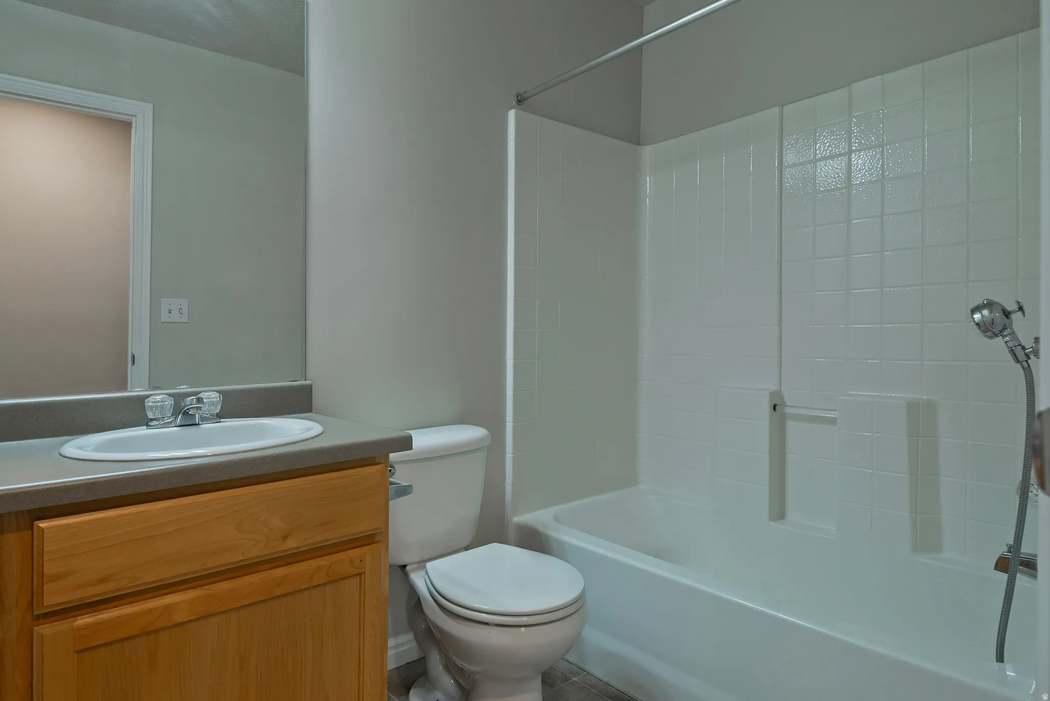 Tub/shower combination with white tile surround