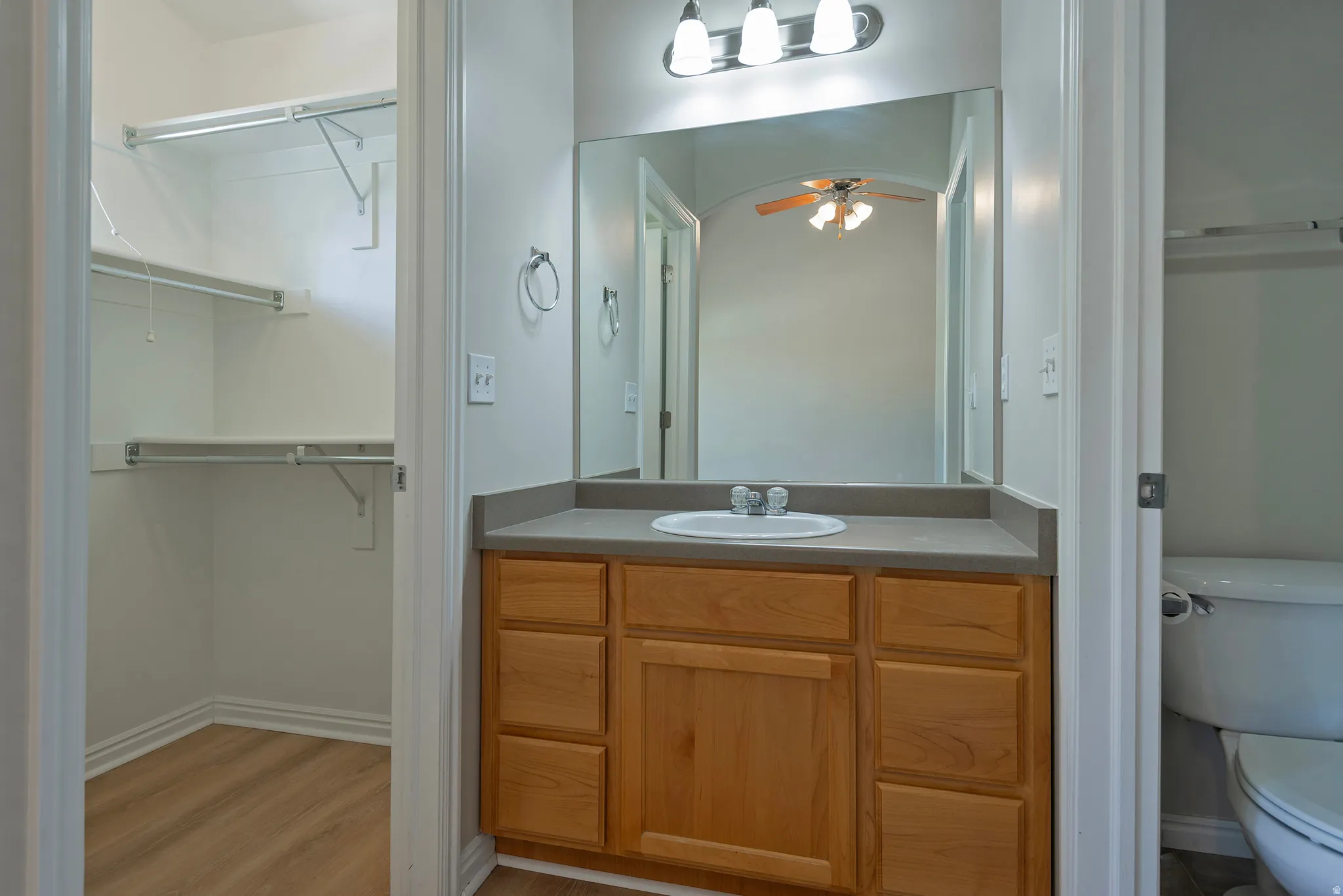 Wood-finish flooring in the closet with multiple shelves