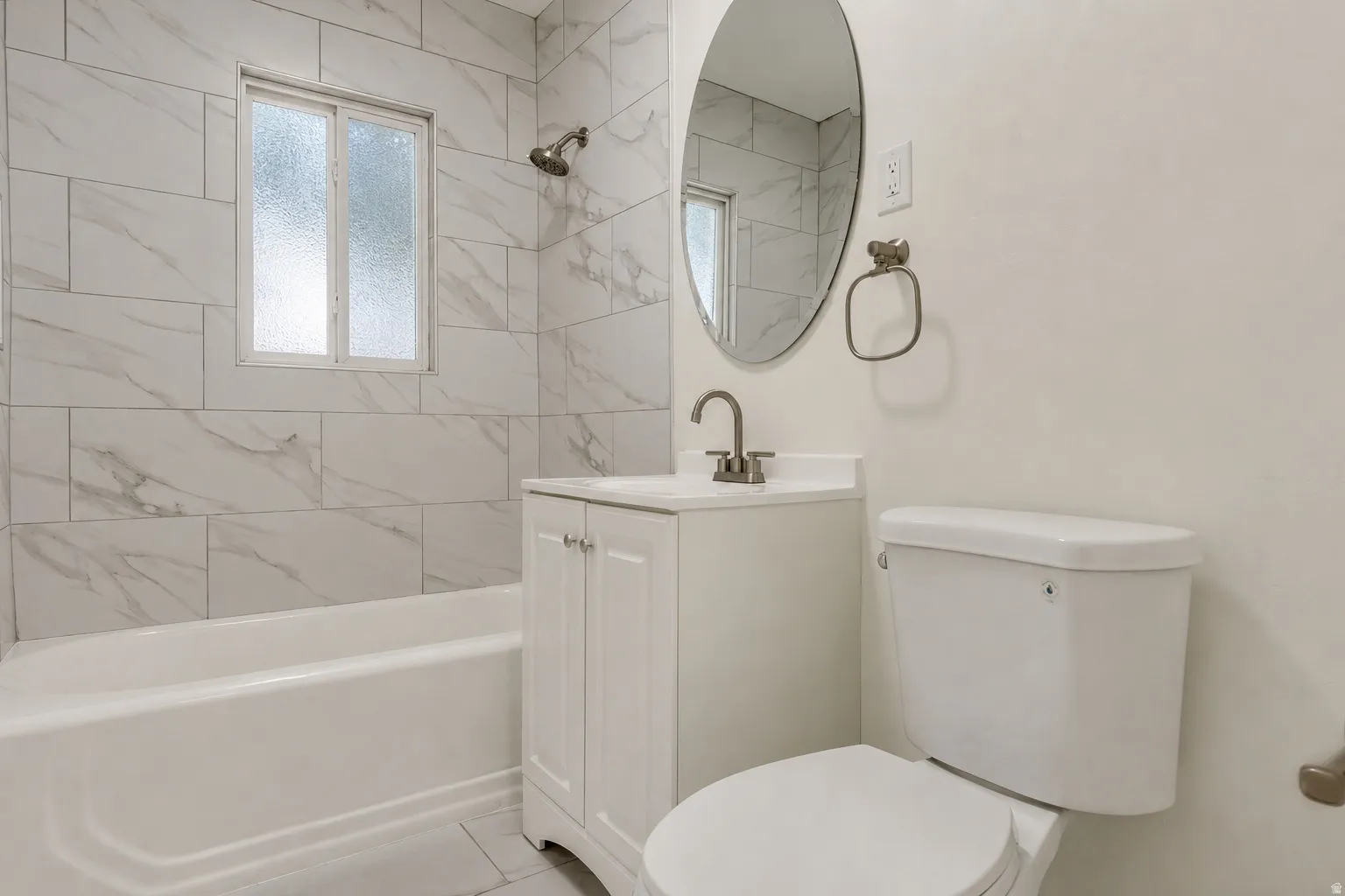 Main floor full bathroom. White subway tile shower surround with a window