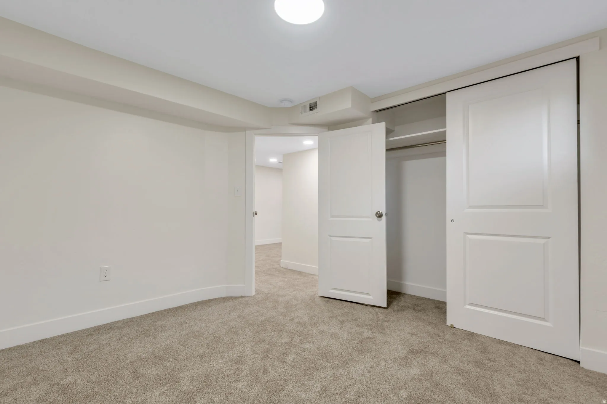 Bedroom 5 - Plush carpeting, recessed lighting, built-in closet with sliding doors, and a paneled interior door