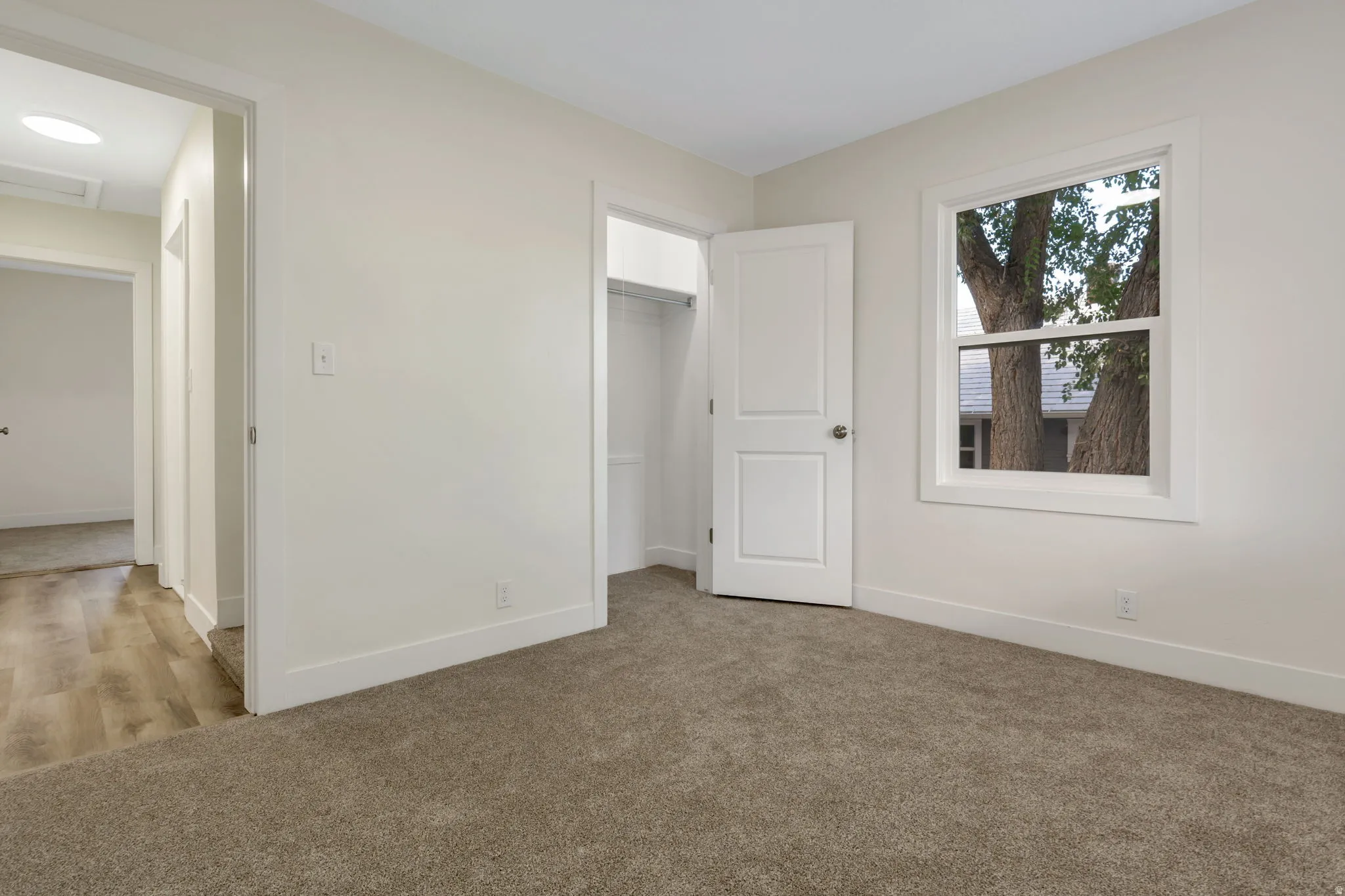 Bedroom 1 - Recessed lighting, neutral wall paint, carpet flooring, a single window, and a built-in closet