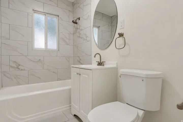 Main floor full bathroom. White subway tile shower surround with a window