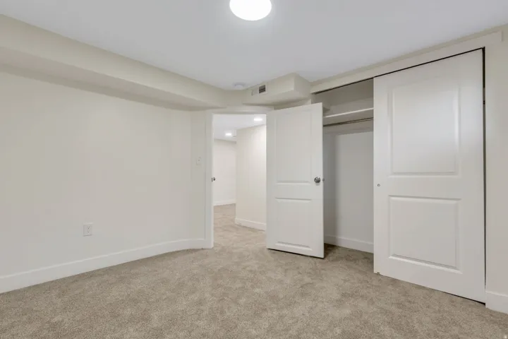 Bedroom 5 - Plush carpeting, recessed lighting, built-in closet with sliding doors, and a paneled interior door
