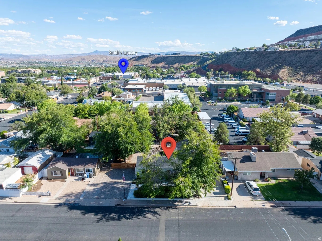 Aerial perspective showcasing the residential street, urban landscape, and distant natural land formations
