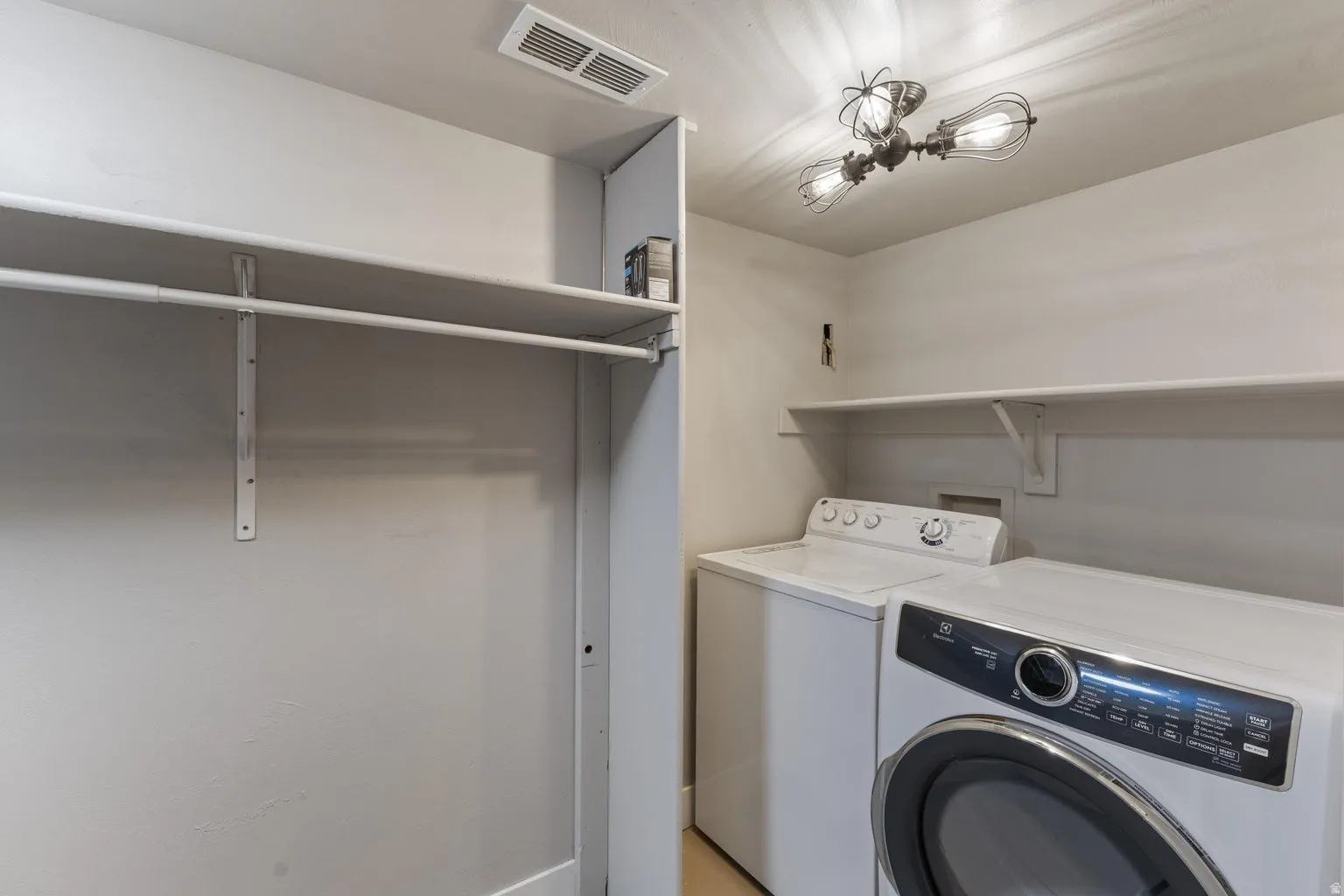 Laundry area with built-in shelving and clothes rod