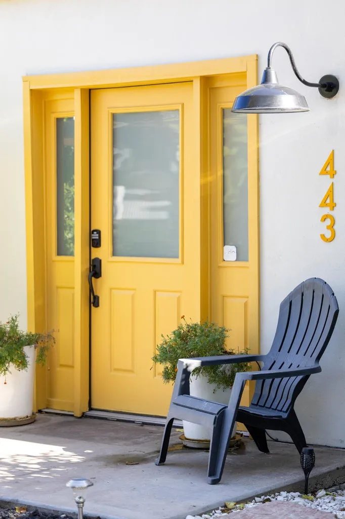 Entry with a yellow door, sidelight windows, and a gooseneck barn light fixture