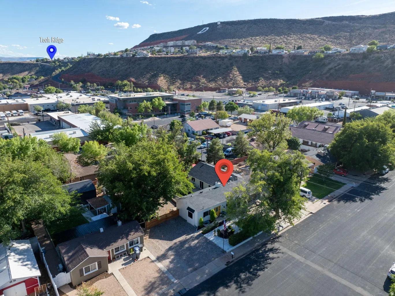 Overhead perspective of a residential property with surrounding neighborhood and distant hillside