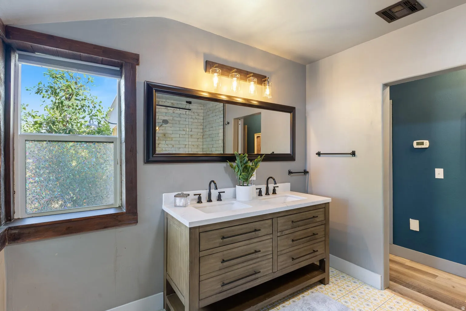 Dual vanity with white countertop and integrated sinks, complemented by matte black faucets