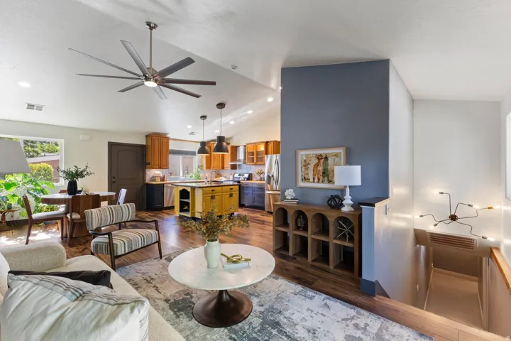 Vaulted ceiling, recessed lighting, wood-finish flooring, kitchen island, and stainless steel appliances