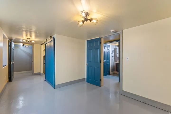 Smooth flooring, multiple doors, and exposed bulb light fixtures