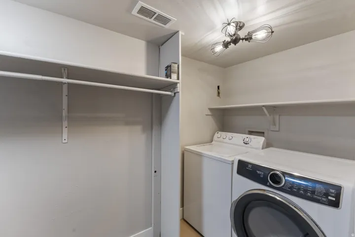 Laundry area with built-in shelving and clothes rod