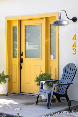 Entry with a yellow door, sidelight windows, and a gooseneck barn light fixture